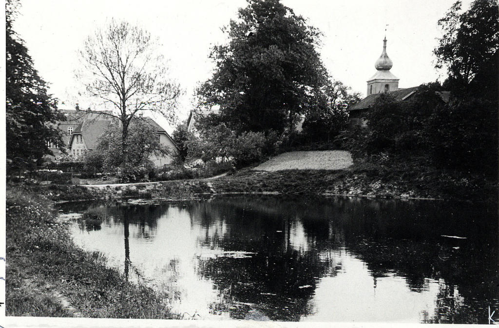 Der Feuerlöschteich, links die Schule, rechts die Kirche um 1935